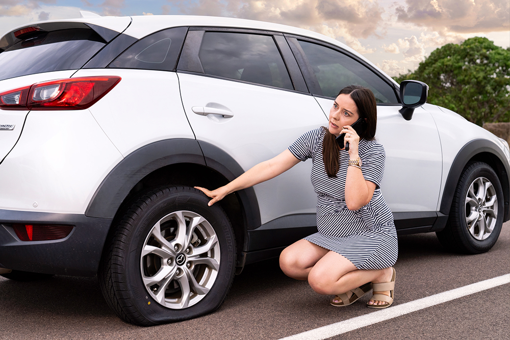 Woman with a flat tyre calling AANT Roadside Assistance