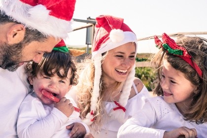 Family at the beach in Christmas hats