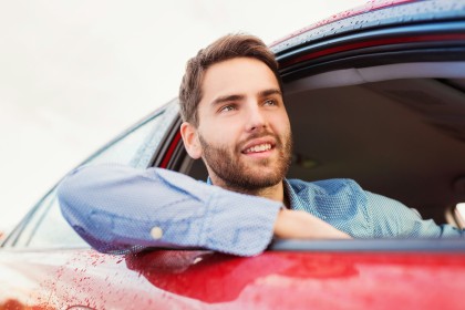 Man leaning out of the window of his car