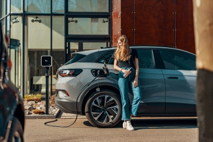 Young woman charging her Electric Vehicle 