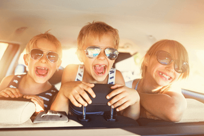 Kids laughing in the back seat of a car