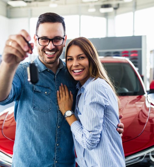 Couple with their new car smiling 